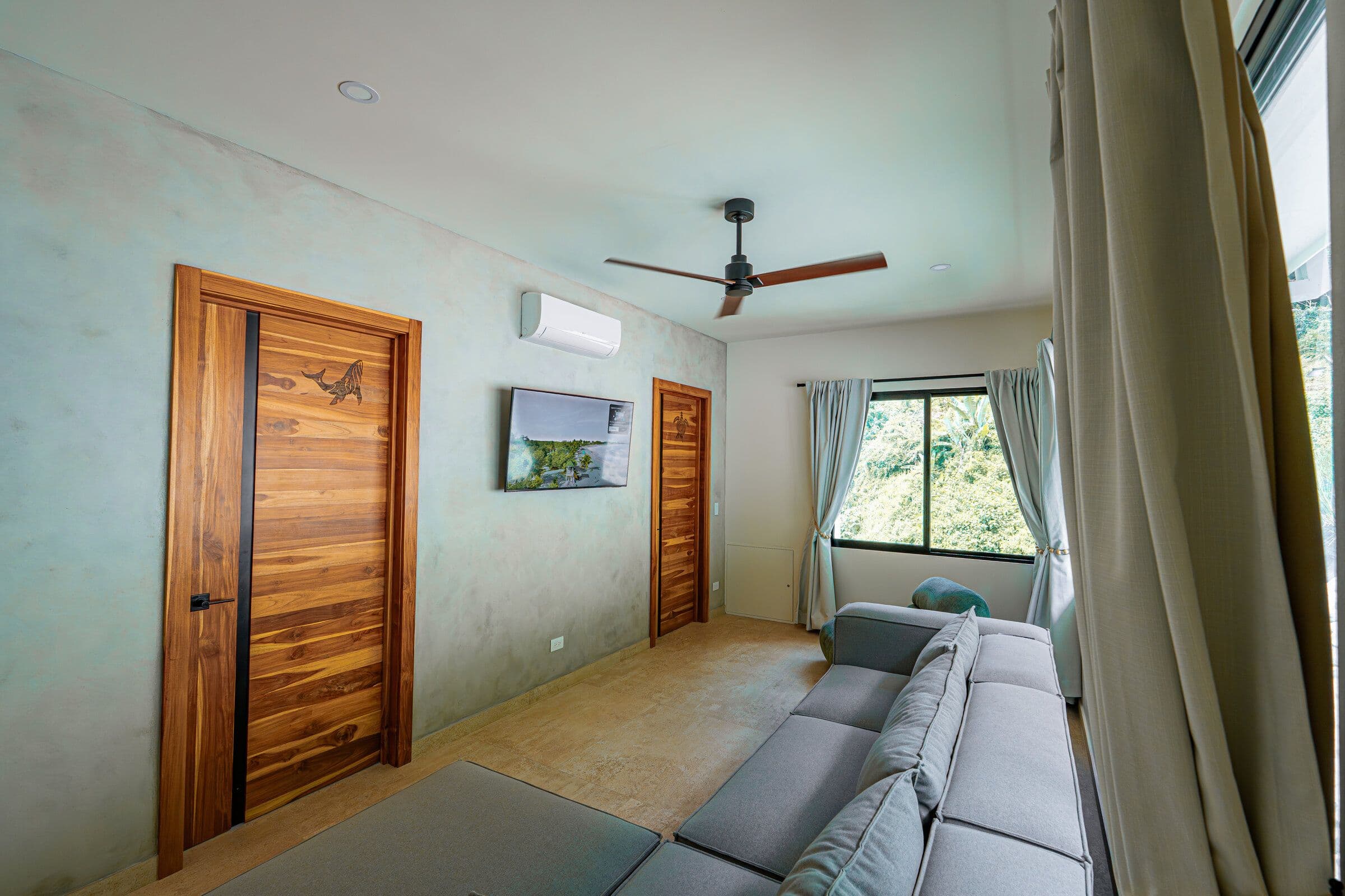 TV room with marlin carved door, sofa, and jungle window